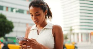 Woman looking at her phone while learning how ultrasounds work during pregnancy confirmation and care